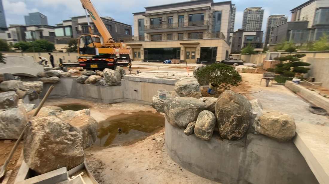 图｜泰山石驳岸沿池体弧线逐步成形